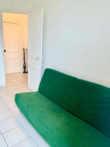 a green couch sitting in a room with a door at Festival de Cannes apartment in Cannes