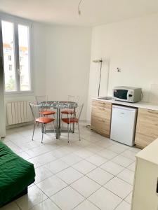 a kitchen with a table and chairs in a room at Festival de Cannes apartment in Cannes