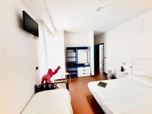 a bedroom with two beds and a red toy on a chair at Hotel Blumen in San Benedetto del Tronto