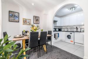 a kitchen and dining room with a table and chairs at Charming 3-Bedroom London Townhouse Balcony in London