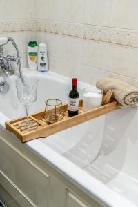 a bathroom sink with a bottle of wine and a glass at Charming 3-Bedroom London Townhouse Balcony in London