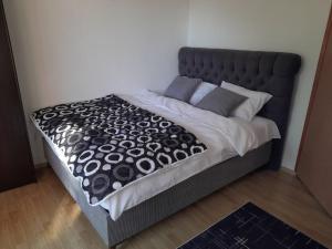 a large bed with a black and white comforter at Sarajevo Holiday Apartments 2 in Sarajevo