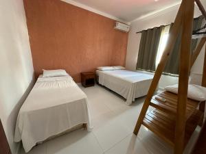 a room with two beds and a staircase in it at Apartamento da Jana a 1,5km praia in Porto Seguro