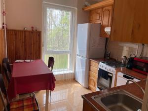 a kitchen with a table and a white refrigerator at Kiss Vendégház 1. in Kaposvár