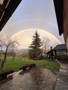 een regenboog in de lucht boven een park met een speeltuin bij Pensiunea Poiana de Vis in Suceviţa