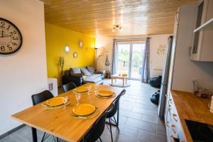 Appartement terrasse du pont Alsort في فرويد-شابيل: غرفة طعام وغرفة معيشة مع طاولة خشبية