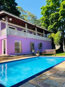 fioletowy dom z basenem przed nim w obiekcie Chácara Aconchegante com Piscina e Salão de Festas w mieście Embu