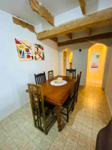 Chácara Aconchegante com Piscina e Salão de Festas في إمبو: غرفة طعام مع طاولة وكراسي خشبية