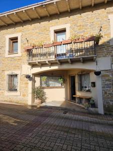 a brick building with a balcony and a patio at Descanso urbano Pamplona in Mutilva Alta