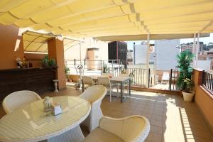 a patio with tables and chairs on a balcony at Royal Inn Aparthotel in Lloret de Mar
