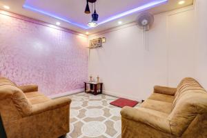 een woonkamer met 2 stoelen en een projectiescherm bij OYO Lee Paradise Inn in Bangalore