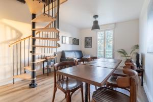 een eetkamer met een houten tafel en een wenteltrap bij Magical Playroom, 10 minutes de Disneyland Paris! in Chessy