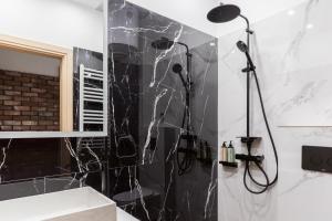 een badkamer met een douche van zwart marmer bij Affogato by halu!: Bright and modern apartment in Thessaloniki