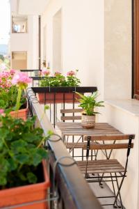 uma fila de mesas e vasos de plantas numa varanda em Four Rooms Alghero em Alghero