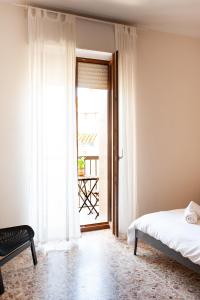 um quarto com uma cama e uma porta para uma varanda em Four Rooms Alghero em Alghero