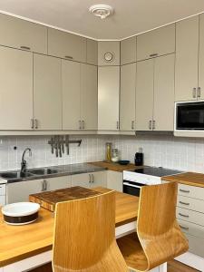 a kitchen with white cabinets and a wooden counter top at City Center Residence - 64 m2 St Eriksplan in Stockholm