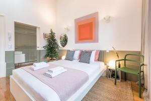 ポルトにあるGuestReady - Charming Studio in Porto!のベッドルーム(白いベッド1台、緑の椅子付)