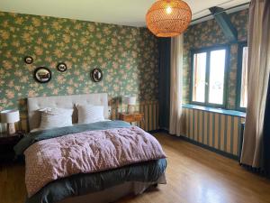 博爾貝克的住宿－BOLBEC Manoir De CALTOT，一间卧室配有一张带花卉壁纸的床和窗户