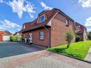 a brick house with a red roof on a street at Kleine Krabbe in Greetsiel