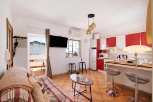 Una sala de estar con un sofá y una cocina. en A Casa de Emy, en Cabanas de Tavira