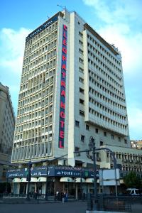 a large building with a red hotel sign on it at Cleopatra Hotel in Cairo