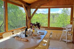a dining room with a table and a large window at With the family -A peaceful stay in the countryside- spa 8-10 pers in Gaugeac