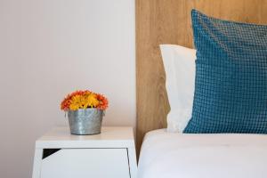 un vaso di fiori su un comodino accanto a un letto di GuestReady - Music Flats 2 a Porto