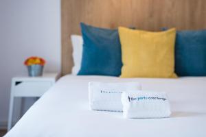 un letto bianco con cuscini blu e un tovagliolo; di GuestReady - Music Flats 2 a Porto Altre 45 foto