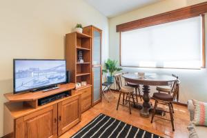 a living room with a television and a dining room table at GuestReady - Sweet & Relax Flat in Porto