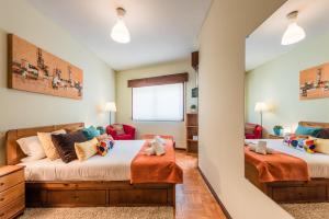a bedroom with two beds and a mirror at GuestReady - Sweet & Relax Flat in Porto