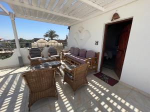 un patio con sillas, un sofá y una mesa en Villa Giulio Luxor Guest House en Luxor