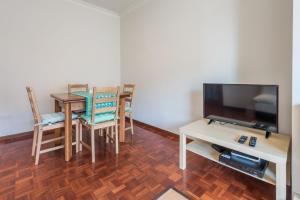 a living room with a dining table and a television at GuestReady - Back to Tullins in Leça da Palmeira