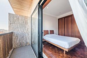 a bedroom with a bed and a glass wall at GuestReady - Back to Tullins in Leça da Palmeira