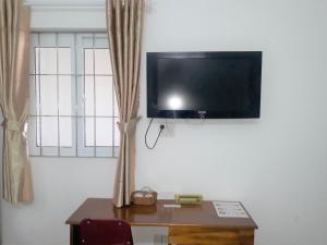 Habitación con mesa y TV en la pared. en Blue Sea 01 Hotel, en Nha Trang