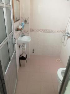 Baño blanco con lavabo y aseo en Blue Sea 01 Hotel, en Nha Trang