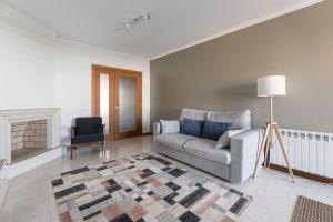 sala de estar con sofá y silla en GuestReady - Urban hideaway near A Prainha Beach, en Vila do Conde