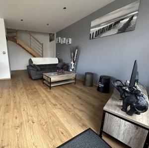 a living room with a couch and a table at gite le C-47 in Sainte-Mère-Église