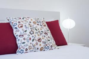 a pillow on top of a bed with red pillows at GuestReady - Beautiful Plateau in Porto