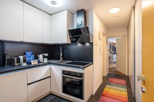 a kitchen with white cabinets and a stove top oven at Zentrale Ferienwohnung mit Balkon in Bad Liebenzell