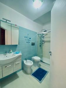 ein Badezimmer mit Toilette, Waschbecken und Dusche in der Unterkunft Casa Vacanza Mare Blu in Villaggio Azzurro + 8 Fotos