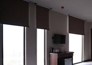 a room with four windows with brown blinds at All Starr Club in Jaipur