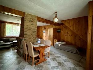 a dining room with a table and a bedroom at Leśna Chata in Olsztynek