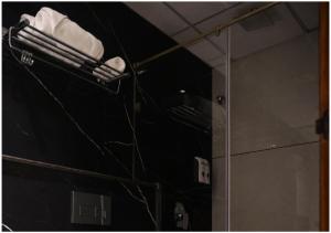 a bathroom with a rack with white towels and a mirror at All Starr Club in Jaipur