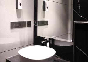 a bathroom with a white toilet and a sink at All Starr Club in Jaipur