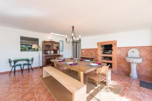 a dining room with a wooden table and a fireplace at GuestReady - Sunset Pool House in Esposende