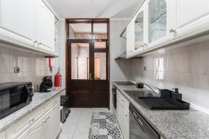 cocina con fregadero y microondas en GuestReady - Sunny Family Apt with Private Terrace, en Oporto