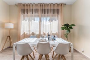 mesa de comedor blanca con sillas y ventana en GuestReady - Sunny Family Apt with Private Terrace, en Oporto