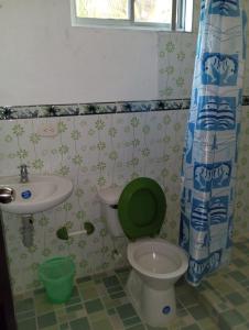 baño con aseo verde y lavamanos en Villa del Carmen e hijos, en San Antero