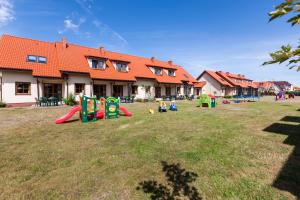 a yard with playground equipment in front of a house at Domki Nautilus-Rowy in Rowy