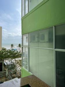 un edificio verde con vistas a la playa en Blue Sea 01 Hotel, en Nha Trang